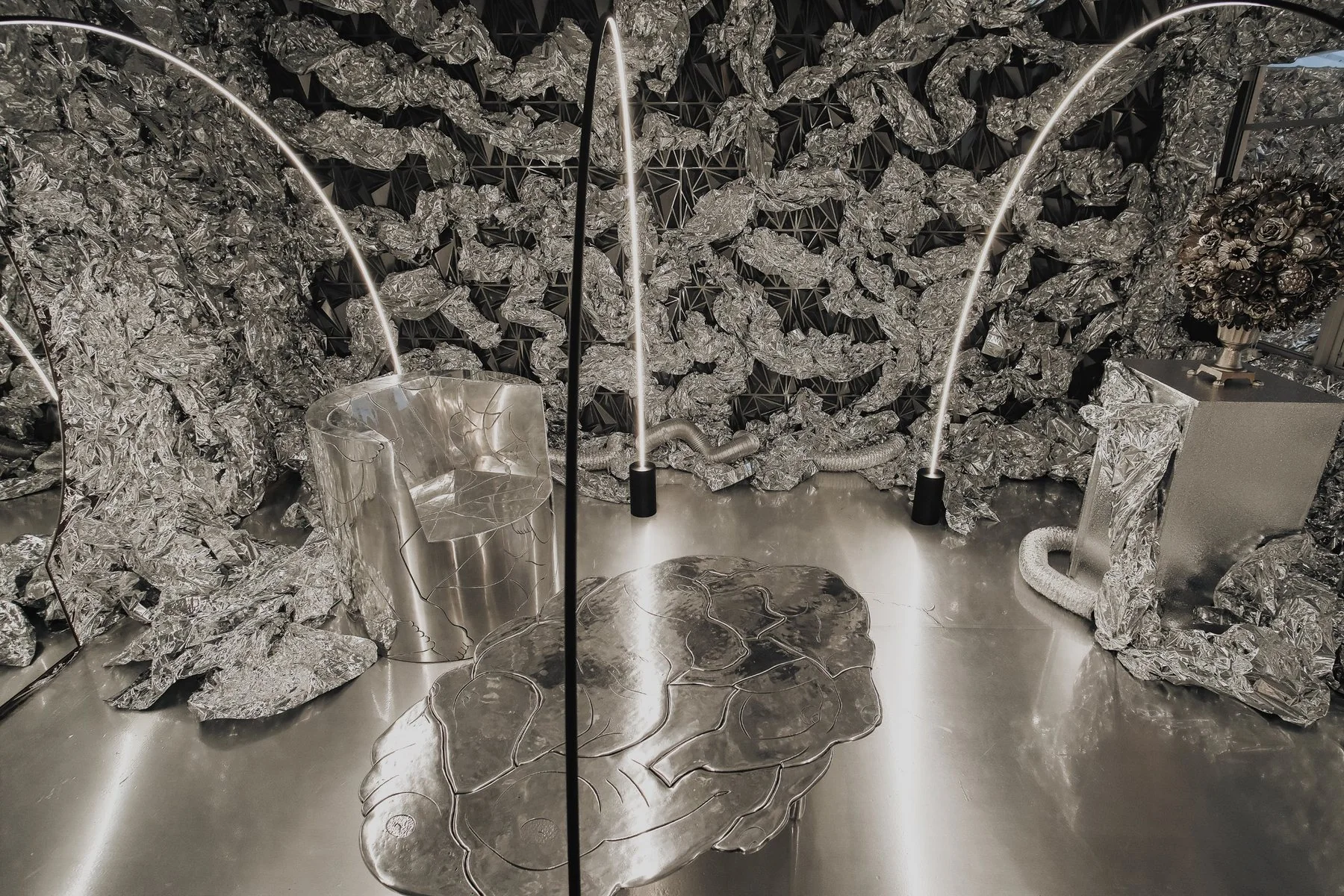 Cosmic diorama: an etched aluminum table and chair inside a silver foil cave