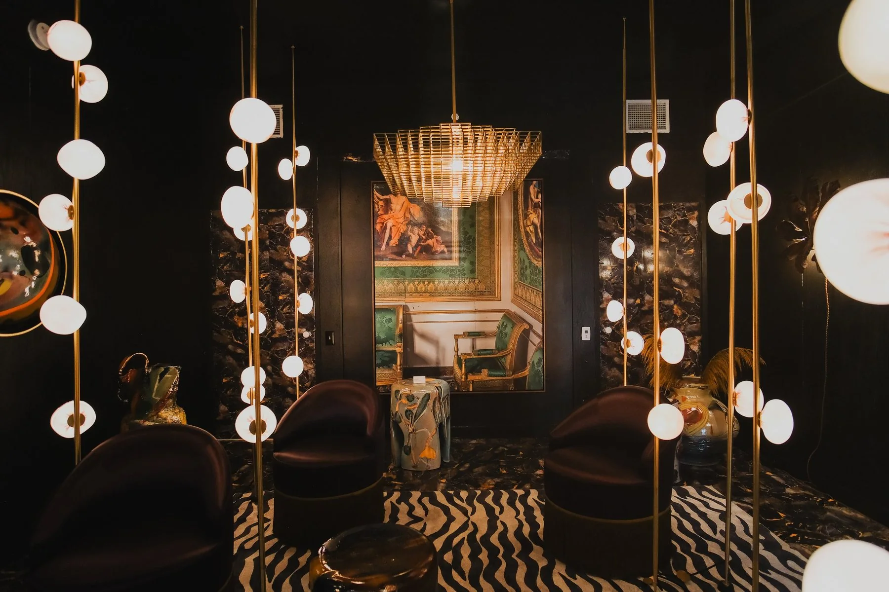 Disco + Design: the Groovy diorama, velvet chairs on a zebra rug under glass globe lights and a gold chandelier